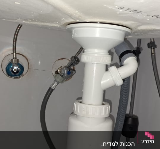 צנרת מתחת לכיור עם חיבורים וצינורות